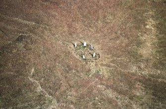 Oblique aerial view centred on the remains of the stone circle, taken from the SW.