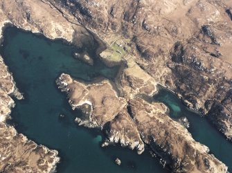 Oblique aerial view centred on the remains of the farmstead and lazy-beds, taken from the SSW.