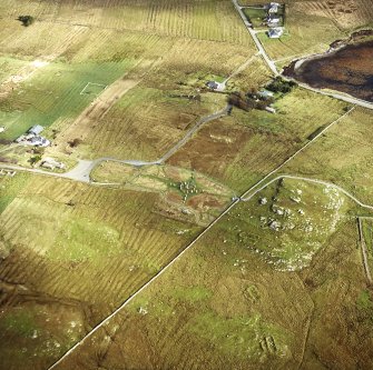 Oblique aerial view centred on the remains of the stone circle and stone alignments with the township and lazy beds adjacent, taken from the W.