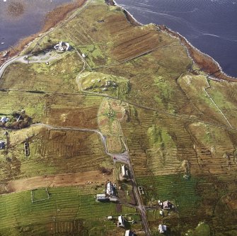 Oblique aerial view centred on the remains of the stone circle, chambered cairn and stone alignments with the township and lazy beds adjacent, taken from the NNE.