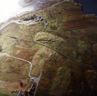 Oblique aerial view centred on the remains of the stone circle, chambered cairn and stone alignments with the township and lazy beds adjacent, taken from the N.