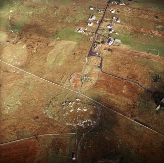 Oblique aerial view centred on the remains of the stone circle, chambered cairn and stone alignments with the township and lazy beds adjacent, taken from the S.