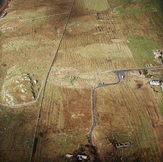 Oblique aerial view centred on the remains of the stone circle, chambered cairn and stone alignments with the township and lazy beds adjacent, taken from the ESE.