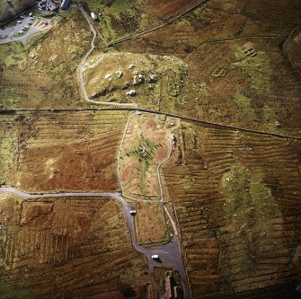 Oblique aerial view centred on the remains of the stone circle, chambered cairn and stone alignments with the township and lazy beds adjacent, taken from the NNE.