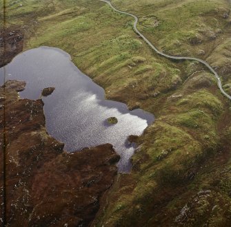 Oblique aerial view centred on the remains of the dun, taken from the NE.