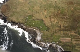 Oblique aerial view centred on remains of the church enclosures and walls with the remains of townships and lazy beds adjacent, taken from the WSW.