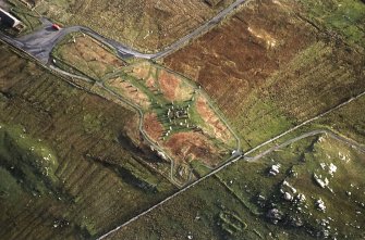 Oblique aerial view centred on the remains of the stone circle, chambered cairn and stone alignments with lazy beds adjacent, taken from the WSW.