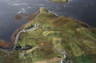 General oblique aerial view centred on the remains of the stone circle, chambered cairn and stone alignments with the farmhouse, visitor centre and township adjacent, taken from the NNE.