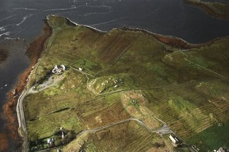 General oblique aerial view centred on the remains of the stone circle, chambered cairn and stone alignments with the farmhouse, visitor centre and township adjacent, taken from the NE.
