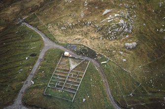 Oblique aerial view centred on the reconstructed shieling hut and sheep pen, taken from the N.