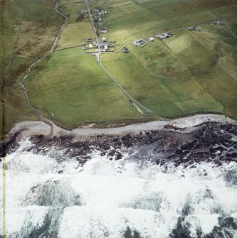 Oblique aerial view centred on the site of the settlement and cemetery with the crofting township and lazy beds adjacent, taken from the N.