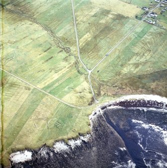 Oblique aerial view centred on the remains of the chapel with the remains of the township adjacent, taken from the WNW.