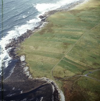 Oblique aerial view centred on the remains of the township with the remains of the chapel adjacent, taken from the SSW.