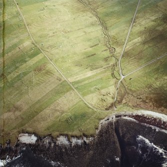 Oblique aerial view centred on the remains of the chapel with the remains of the township adjacent, taken from the W.