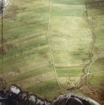 Oblique aerial view centred on the remains of the township with the remains of the chapel adjacent, taken from the WSW.