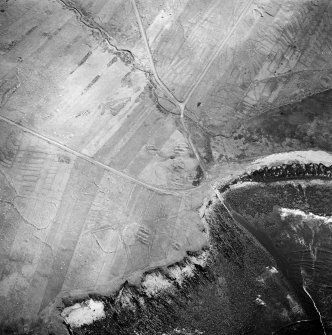 Oblique aerial view centred on the remains of the chapel with the remains of the township adjacent, taken from the WNW.