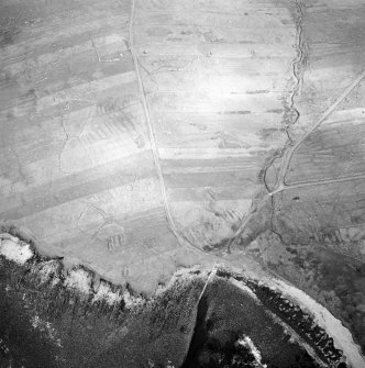 Oblique aerial view centred on the remains of the chapel with the remains of the township adjacent, taken from the WSW.