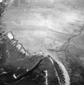 Oblique aerial view centred on the remains of the chapel with the remains of the township adjacent, taken from the SW.