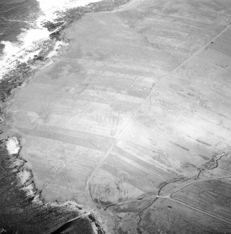 Oblique aerial view centred on the remains of the township with the remains of the chapel adjacent, taken from the SSW.