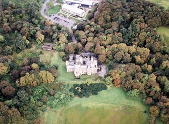 Oblique aerial view centred on the country house and college, taken from the SE.