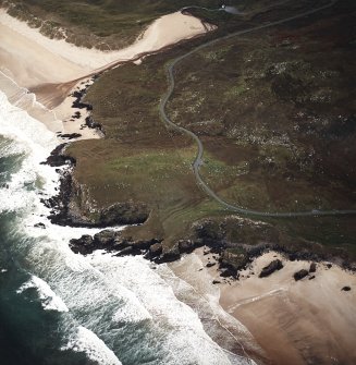 Oblique aerial view centred on the remains of the lazy beds and possible promontory fort with the dun and possible shieling-hut, adjacent, taken from the NNE.