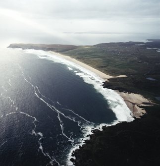 General oblique aerial view looking across the remains of the dun, possible promontory fort and lazy beds towards Tolstadh Traigh Mor beach, taken from the NNE.