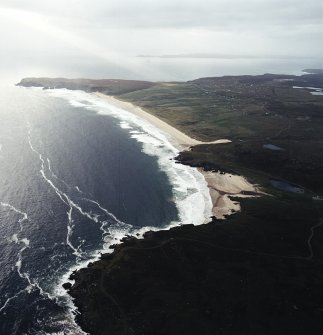 General oblique aerial view looking across the remains of the dun, possible promontory fort and lazy beds towards Tolstadh Traigh Mor beach, taken from the NNE.