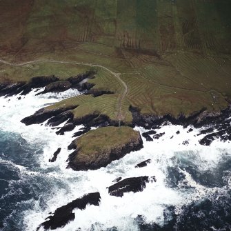 Oblique aerial view centred on the remains of the settlement with the remains of lazy beds adjacent, taken from the NNE.