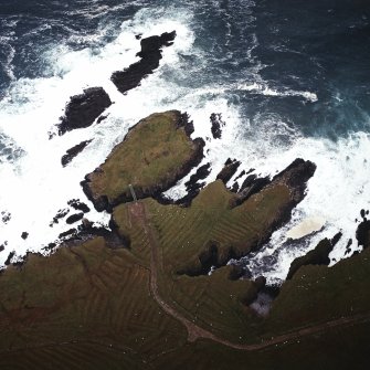 Oblique aerial view centred on the remains of the settlement with the remains of lazy beds adjacent, taken from the SW.