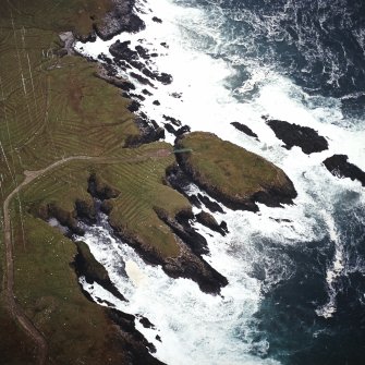 Oblique aerial view centred on the remains of the settlement with the remains of lazy beds adjacent, taken from the SE.