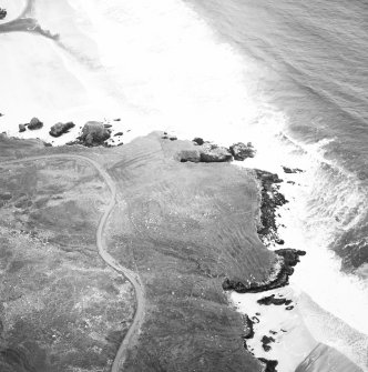 Oblique aerial view centred on the remains of the lazy beds and possible promontory fort with the dun and possible shieling-hut, adjacent, taken from the SSW.