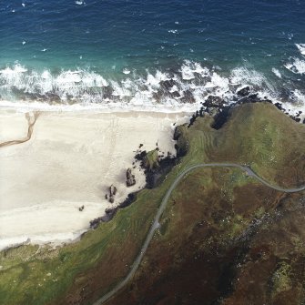 Oblique aerial view centred on the remains of the dun with the remains of the possible promontory fort, lazy beds and possible shieling-hut adjacent, taken from the W.