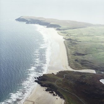 General oblique aerial view looking across the remains of the dun towards Tolstadh Traigh Mor beach, taken from the NNW.