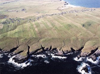 Oblique aerial view centred on the remains of lazy beds with the townships and chapel adjacent, taken from the NE.