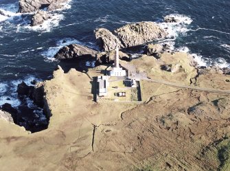 Oblique aerial view centred on the lighthouse with the enclosure adjacent, taken from the SW.