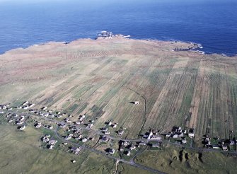 Oblique aerial view centred on St Moluag's chapel and township with lazy beds at Eoropie, Lewis and Butt of Lewis lighthouse adjacent, taken from the S.