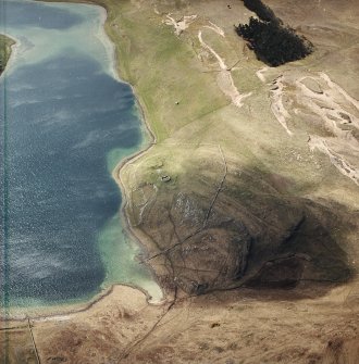 Oblique aerial view centred on the remains of the possible dun, longhouses, buildings and enclosure with longhouse, enclosure, possible farmstead and building adjacent, taken from the ENE.