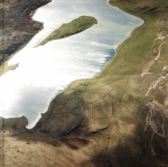 Oblique aerial view centred on the remains of the possible dun, longhouses, buildings and enclosure with longhouse, enclosure, possible farmstead and building adjacent, taken from the NNE.