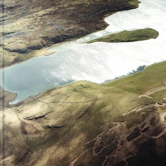 Oblique aerial view centred on the remains of the possible dun, longhouses, buildings and enclosure with longhouse and possible farmstead adjacent, taken from the NNW.