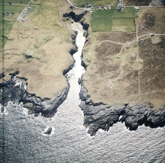 Oblique aerial view centred on the Smoo cave with the remains of the radar station and crofting townships adjacent, taken from the NNE.