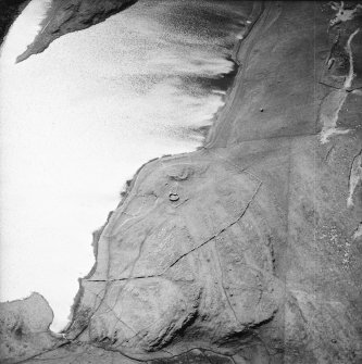 Oblique aerial view centred on the remains of the possible dun, longhouses, buildings and enclosure with longhouse, enclosure, possible farmstead and building adjacent, taken from the NE.