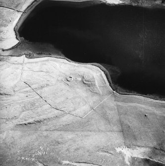 Oblique aerial view centred on the remains of the possible dun, longhouses, buildings and enclosure with longhouse adjacent, taken from the WNW.