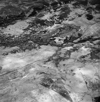 Torbreck Burn, oblique aerial view, taken from the E, showing areas defined as archaeological landscapes in the centre and top half of the photograph. A hut-circle, small cairns and rig are visible in the bottom left-hand corner area.