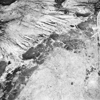 Cnoc Achadh na h-Uaighe, Achnahuie, oblique aerial view, taken from the NW, showing small cairns in the centre of the photograph, and an area with a hut-circle, small cairns, lynchets and a possible hut in the bottom right-hand corner.