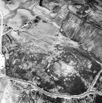 Dremergid, oblique aerial view, taken from the NNE, centred on an area defined as an archaeological landscape, and burnt mounds. Two buildings, a farmstead and hut are visible in the top half of the photograph, and a hut-circle, small cairns and a bank are shown in the bottom left-hand corner.