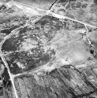 Dremergid, oblique aerial view, taken from the NW, centred on an area defined as an archaeological landscape, burnt mounds and a building. In the upper half of the photograph an area with a hut-circle, small cairns and a bank is visible, and immediately beside it is another area with a hut-circle and field-system.