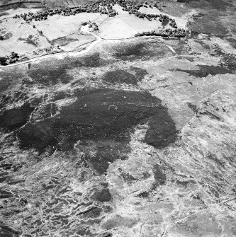 Cnoc Cairaidh, Achnagarron, oblique aerial view, taken from the NE, centred on an area with hut-circles, a field-system and possible cord rig. Standing stones, small cairns and a building are visible in the centre top half of the photograph.