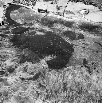 Cnoc Cairaidh, Achnagarron, oblique aerial view, taken from the NE, centred on an area with hut-circles, a field-system and possible cord rig. Standing stones, a hut-circle, small cairns and a building are visible in the top half of the photograph.