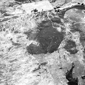 Cnoc Cairaidh, Achnagarron, oblique aerial view, taken from the NW, centred on an area with hut-circles, a field-system and possible cord rig. A hut-circle, small cairns and a farmstead are visible in the top half of the photograph.