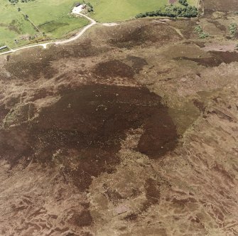 Cnoc Cairaidh, Achnagarron, oblique aerial view, taken from the NE, centred on an area with hut-circles, a field-system and possible cord rig. Standing stones and a building are visible in the centre top half of the photograph.